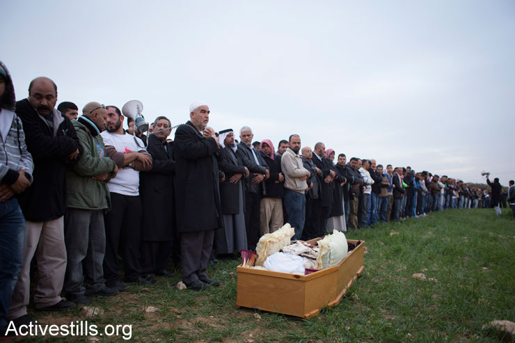 Bedouin mourners pray near the body of Sami Ziadna, 43, during his funeral in the southern Bedouin city of Rahat, January 19, 2015. Sami died a day earlier following clashes with Israeli police during the funeral of another Bedouin man who was killed a week earlier by Israeli policemen in the city. (Photo by Activestills.org)