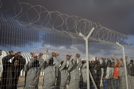 African asylum seekers jailed in the Holot detention center protest behind the prison's fence, February 17, 2014. (Photo by Activestills.org)