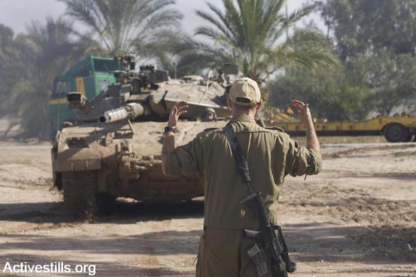 File photo of an Israeli soldier directing a tank. (Photo by Oren Ziv/Activestills.org)
