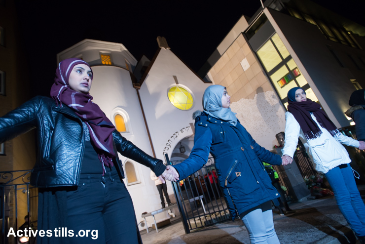 Young Muslim women stand hand-in-hand in front of the Oslo Synagogue during the "Ring of Peace" vigil, February 21, 2015. The vigil was organized by Muslim youth in solidarity with Norway's Jewish community following anti-Jewish attacks in Denmark and other parts of Europe.