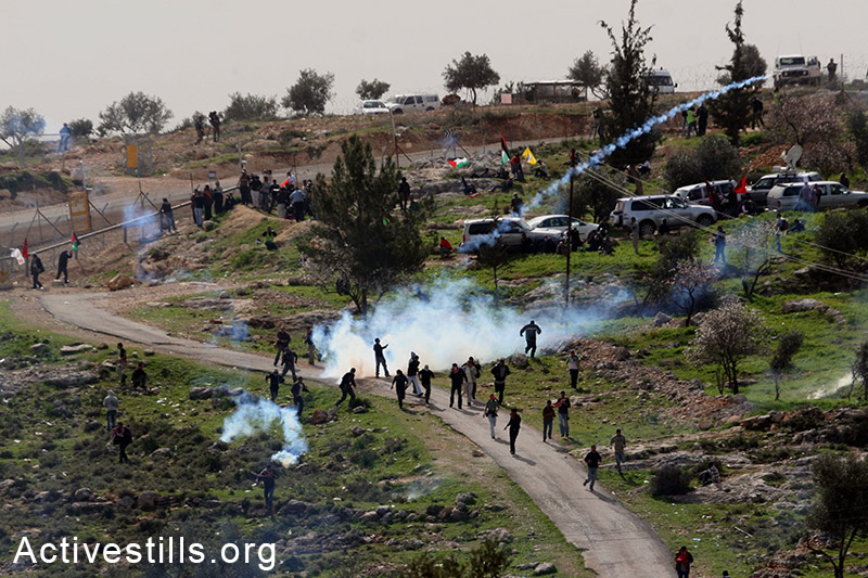 Activists run during a protest against the Wall, Bil'in, West Bank, 2008. Tess Schaflan / Activestills.org