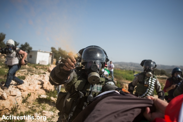 An Israeli border policeman uses pepper spray against a protester during a demonstration marking a decade of popular struggle against the wall in the West Bank village Bil'in, February 27, 2015. (photo: Yotam Ronen/Activestills.org)