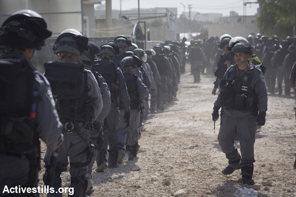 Dozens of police officers in riot gear outside the Naqib family home. (Oren Ziv/Activestills.org)