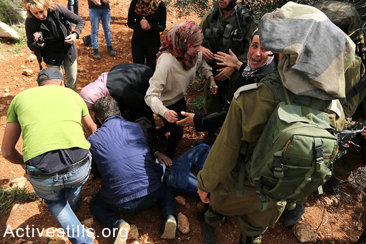 A Palestinian woman tries to protect a youth from arrest.  (photo: Activestills.org)