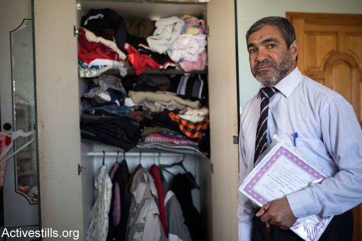 Ahmed al-Nashash, 50, stands in front of a closet that still contains clothes belonging to his sons, who were killed during the last Israeli offensive, Rafah City, Gaza Strip, March 18, 2015. The al-Nashash family was fleeing attacks on July 27, 2014, when they were struck by an Israeli missile some 100 meters from their home. Seven members of the family were killed, including his wife of Ahmad, Hana (45), and their five sons. Two of his daughters, Meena (4) and Fatma (2) survived.