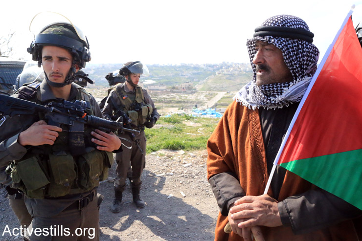 Palestinian, Israeli and international activists protest against the Israeli plan to build new settlements in the E1 area of the West Bank, Eizariya, West Bank, March 17, 2015. (Ahmad al-Bazz/Activestills.org)