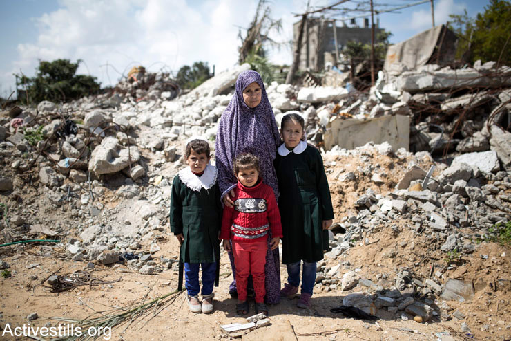Elizabeth Tanboura stands with three of her daughters: Sundos, Malak, and Marwa (right), in front of their destroyed home in Beit Lahiya, Gaza Strip, March 19, 2015. Elizabth's husband, Radad, and their children Ahmed (15) and Amna (13), were killed during an Israeli attack on August 25, 2014. Two other boys survived because they were not in the house at the time of the attack.