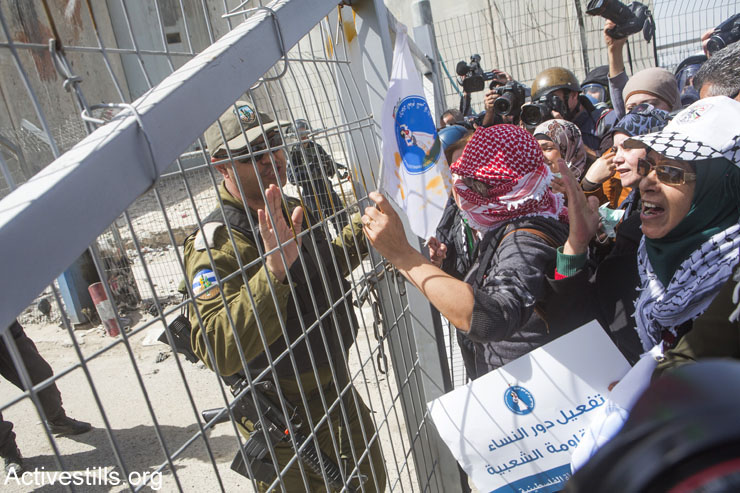 Palestinian women approach the fence leading to Qalandia checkpoint separating Ramallah and Jerusalem. Israeli soldiers broke up the joint Israeli-Palestinian protest against the occupation, marking International Women’s Day, March 7, 2015. (Anne Paq/Activestills.org)