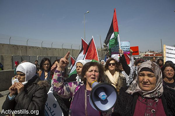 Palestinian women march toward the Qalandia checkpoint separating Ramallah and Jerusalem. Israeli soldiers broke up the joint Israeli-Palestinian protest against the occupation, a day before International Women’s Day, March 7, 2015. (Anne Paq/Activestills.org)