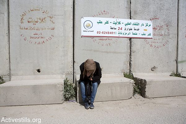 A Palestinian woman suffers from tear gas inhalation during a demonstration against the occupation held one day before International Women's Day, at Qalandia checkpoint, West Bank, March 7, 2015. (Anne Paq/Activestills.org)