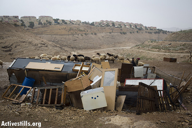 A sheep shelter constructed out of old furniture in a Bedouin camp in the E1 area, situated between Jerusalem and the Israeli West Bank settlement of Maale Adumim (background). (Photo: Oren Ziv/Activestills.org)