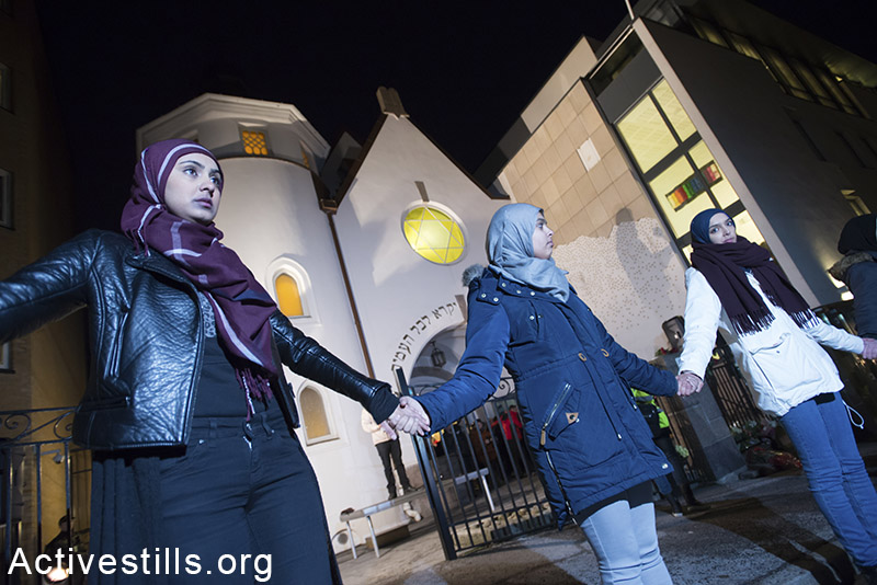 Young Muslim women stand hand-in-hand in front of the Oslo Synagogue during the "Ring of Peace" vigil, February 21, 2015. The vigil was organized by Muslim youth in solidarity with Norway's Jewish community following anti-Jewish attacks in Denmark and other parts of Europe. Ryan Rodrick Beiler / Activestills.org