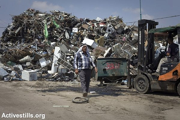 A resident works at a metal recycling compound, in the unrecognised village of Dahamash, Israel, July 22, 2010. (photo: Oren Ziv/Activestills.org)