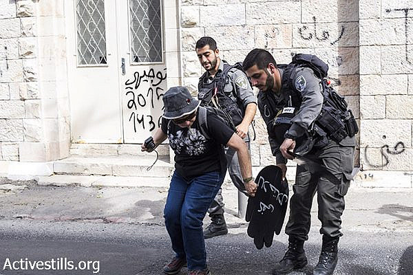 And Israeli policemen confiscates a sign from a protester during a demonstration against the Judaization of Sheikh Jarrah, East Jerusalem, March 27, 2015. (photo: Mareike Lauken, Keren Manor/Activestills.org)