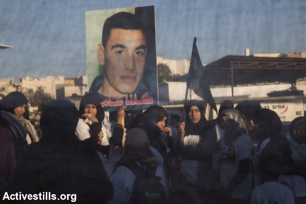 Bedouin women carry a photo of Sami al-Jaar during a march in the southern Bedouin city of Rahat condemning the death of two residents of the town by Israeli police, Negev Desert, January 20, 2015. (Photo by Oren Ziv/Activestills.org)