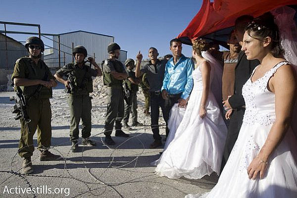 Palestinian demonstrators hold a mock wedding during a nonviolent demonstration in the West Bank village Al-Ma'asara, July 31, 2009. (photo: Oren Ziv/Activestills.org)