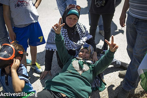 Manal Tamimi making a V sign after she was shot with life ammunition, during the weekly protest against the occupation, Nabi Saleh, West Bank, April 3, 2015. Anne Paq / Activestills.org