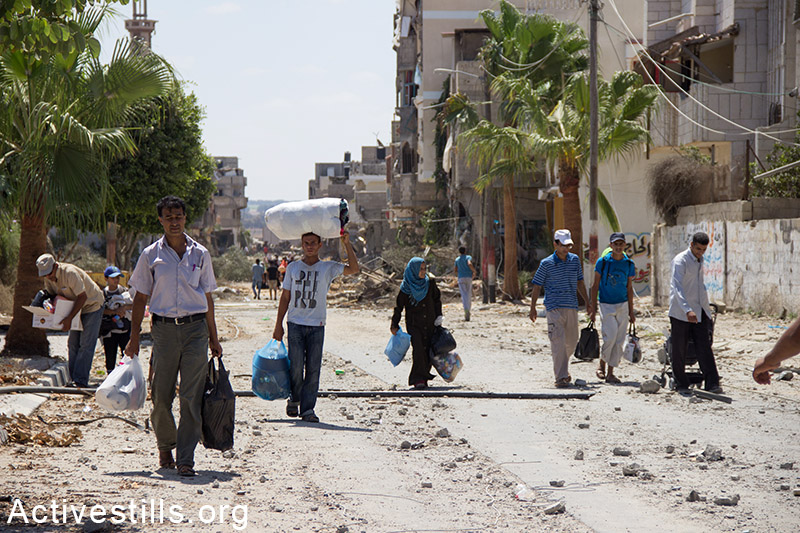 Palestinians leave Khuza'a following bombardment by Israeli forces, Gaza Strip, August 3, 2014. Basel Yazouri / Activestills.org