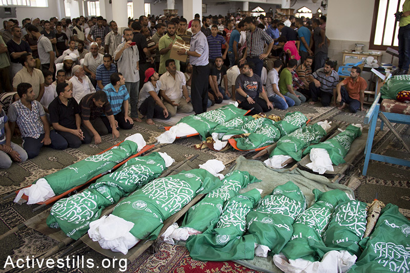 Funeral for the 26 members of the Abu Jame' family, who were killed the previous day during an Israeli attack over the Bani Suhaila neighborhood of Khan Younis, Gaza Strip, July 21, 2014. Basel Yazouri / Activestills.org