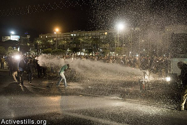 Police sprays protesters with coloured water during an Israeli Ethiopian protest against police brutality and racism, Tel Aviv, May 3rd, 2015. Oren Ziv / Activestills.org