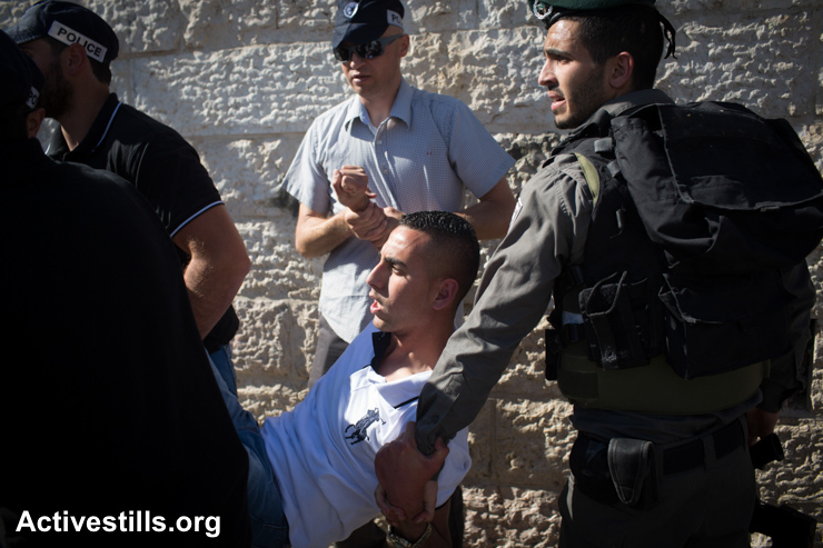 Israeli policemen arrest a Palestinian youth during the "Jerusalem Day" march held by Israeli nationalists to celebrate 48 years of the Israeli occupation of East Jerusalem, May 17, 2015.