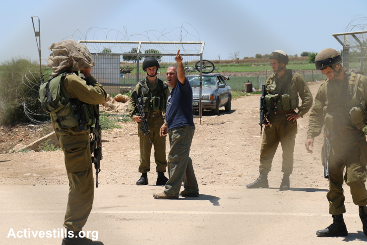 A Palestinian farmer argues with Israeli soldiers on the western side of the Separation Wall in Falamya village, West Bank, May 17, 2015. Farmers from four villages: Kafr Jammal, Kafr Zibad, Kafr Abbush and Kafr Sur have been informed that access to their agricultural lands through this gate will be closed by Israeli forces for three days, starting May 17. Farmers said they have been forced to go through another gate in the village of Jayyous, which is about 15 kilometers from the gate at Falamya.