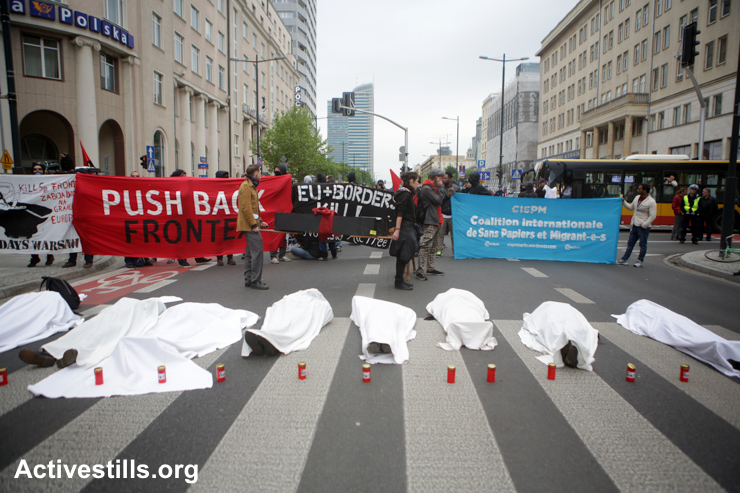 Activists lie wrapped in white sheets to symbolize migrants who died in the Mediterranean, during a protest of migrants, refugees and supporting activists against the European agency Frontex, in Warsaw, Poland, May 21, 2015.