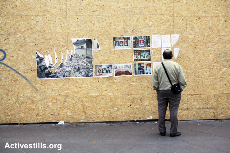 A man looks at an Activestills street exhibition on Gaza which was damaged in Marseille, France, May 8, 2015. The photo exhibitions, which were put in various locations in the city, featured photos taken by Anne Paq for a project about families who were killed (partially or entirely) during the Israel's 2014 military offensive on Gaza.