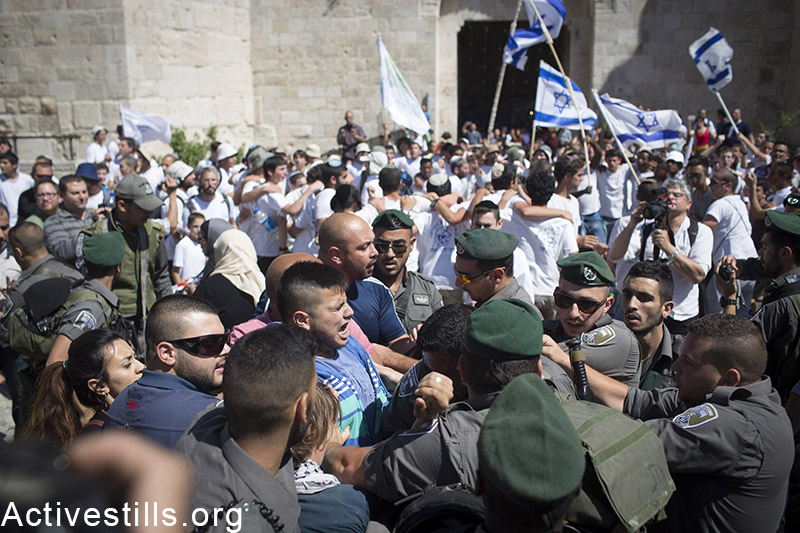 Israeli policemen arrest as Palestinian youth, outside Jerusalem's old city, as Palestinians protest against the flags march, May 17, 2015. The march marks 48 years for the occupation of East Jerusalem.