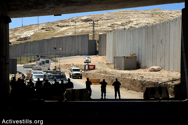 Israeli soldiers are seen nearby the closed gate that leads from Jerusalem to the village of Al Zaeem, West Bank, May 8, 2015. The gate is held closed by Israeli authorities for over two weeks.  Ahmad al-Bazz / Activestills.org