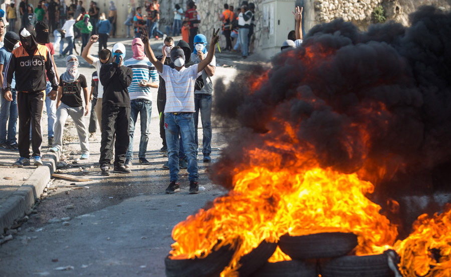 Palestinian youth burn tires during clashes with Israeli police in the East Jerusalem neighborhood of Issawiya, October 24, 2014. (Activestills.org)
