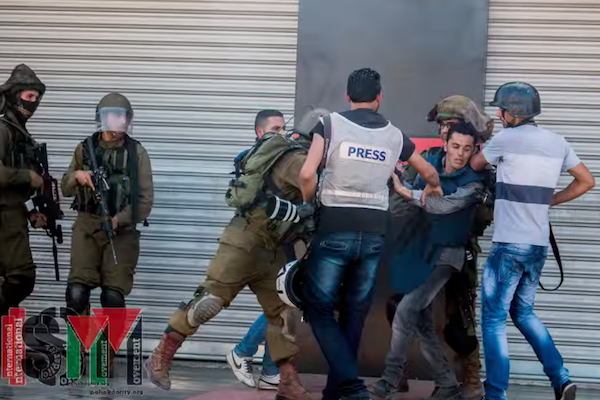 Soldiers assault journalists during clashes at Jalazone refugee camp in the West Bank. (photo by ISM)