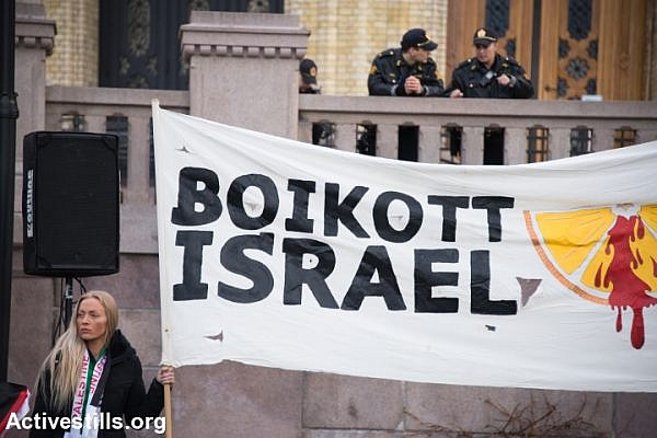 Police watch from above as solidarity activists hold a banner reading "Boycott Israel" during a protest in front of the Norwegian Parliament building, Stortinget, Oslo, March 30, 2015. (photo: Ryan Rodrick Beiler/Activestills.org)