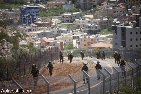 File photo of Israeli soldiers patrolling along the Syrian border in the Israeli-annexed Golan Heights, Majdal Shams. (Photo by Oren Ziv/Activestills.org)