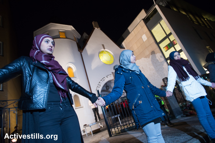 Young Muslim women stand hand-in-hand in front of the Oslo Synagogue during the "Ring of Peace" vigil, February 21, 2015. The vigil was organized by Muslim youth in solidarity with Norway's Jewish community following anti-Jewish attacks in Denmark and other parts of Europe. (photo: Ryan Rodrick Beiler/Activestills.org)