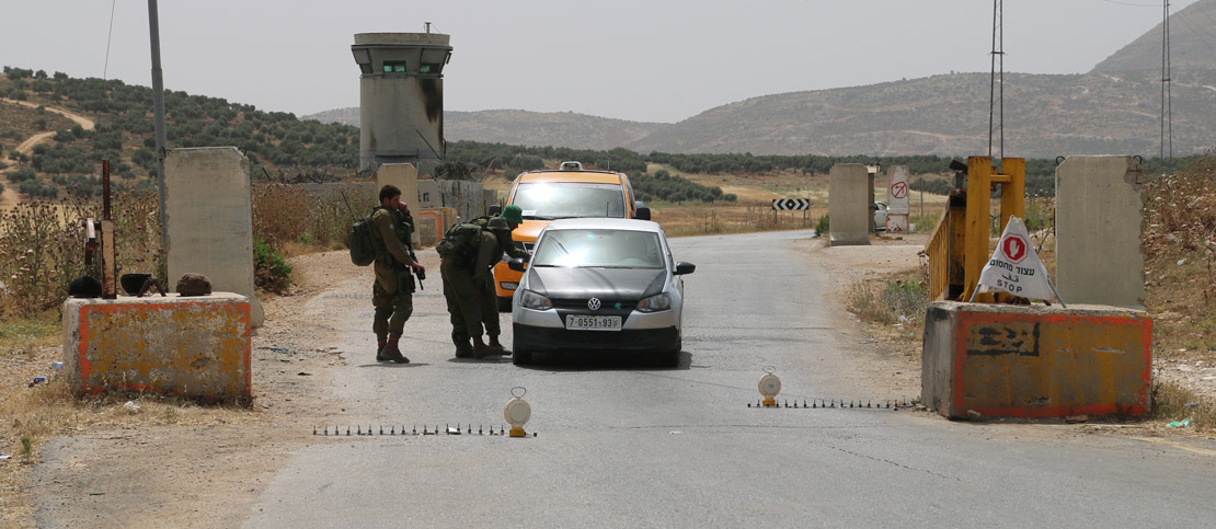 Israeli soldiers check cars at a checkpoint in the West Bank, May 27, 2015. (Activestills.org)
