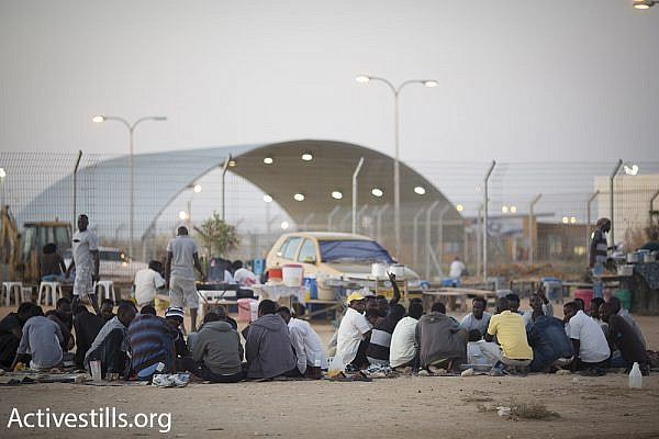 Asylum seekers eat in makeshift restaurants owned by other detainees, outside the Holot detention center’s gates, July 2015. (Oren Ziv/Activestills.org)