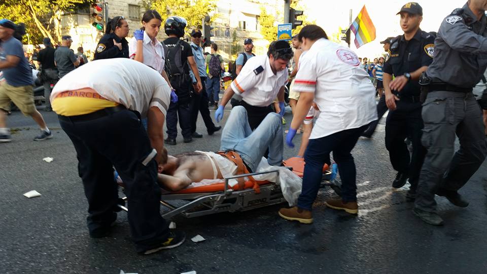 A man is carried away by Magen David Adom emergency services after being stabbed during the Jerusalem Pride Parade, July 30, 2015. (photo: Sarit Michaeli)