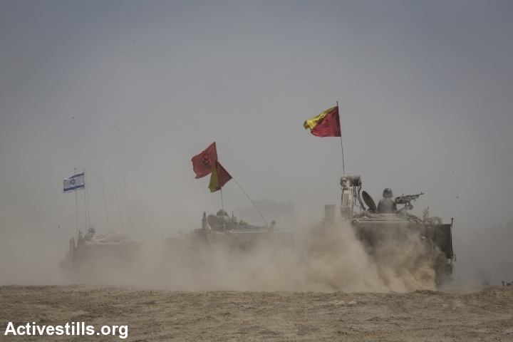 Merkava tanks and APC's maneuver near the border between Israel and the Gaza Strip, August 5, 2014. (Oren Ziv/Activestills.org)