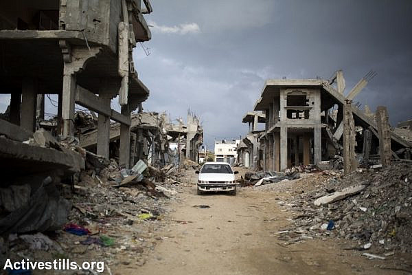 Palestinians drive through a destroyed quarter of Al Shaaf area in Al Tuffah, east of Gaza City, March 21, 2015. (Anne Paq/Activestills.org)