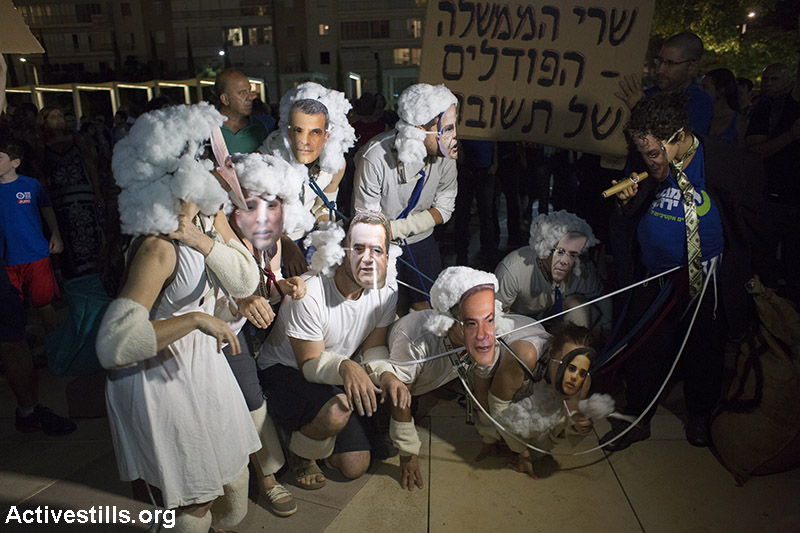 Protester illustrating government weakens regarding energy companies during a protest against natural gas privatisation in Tel Aviv, June 27, 2015. Around 4000 people marched in protest of the government's policies regarding the privatisation of natural gas found in the Mediterranean sea. (Activestills.org)