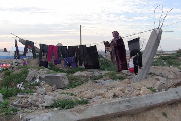 Hanging laundry from rubble in what was once the Awajah family home, destroyed during the 2014 war. (Photo by Jen Marlowe