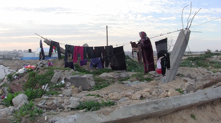 Hanging laundry from rubble in what was once the Awajah family home, destroyed during the 2014 war. (Photo by Jen Marlowe