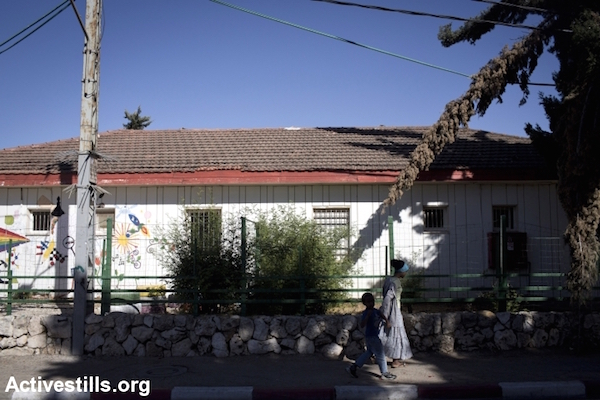 Ethiopian Jewish immigrants walk past an immigrant absorption center in Mevaseret Zion, near Jerusalem, May 1, 2014. (Oren Ziv/Activestills.org)