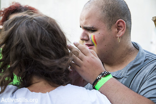 A man is seen crying following a mass stabbing attack against the Jerusalem LGBTQ Pride Parade in Jerusalem, July 30, 2015. (Keren Manor/Activestills.org)