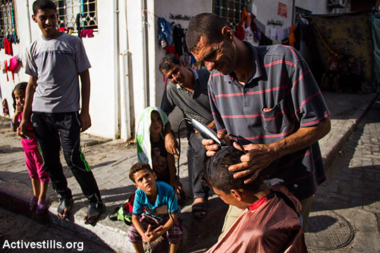 Gazans who evacuated their houses to find emergency shelter go on with the activities of daily life, Al-Shifa Hospital, August 9, 2014. According to UN figures, at least 425,000 people have fled their homes in search of safe shelter including UNRWA schools, government buildings, and host families.