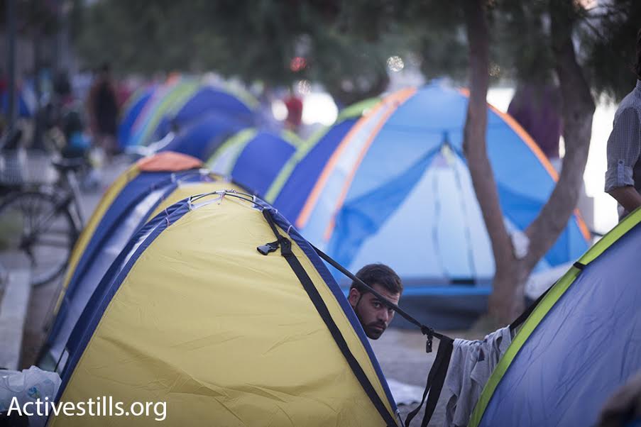 A Syrian refugee sits in his tent on the beach in Kos, Greece, September 9, 2015. (photo: Oren Ziv/Activestills.org)