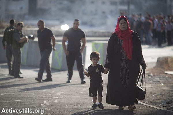 Israeli border policemen stop and check Palestinians going out of the East Jerusalem neighbourhood of Issawiya, on October 15, 2015. Israel set up checkpoints in the Palestinian neighbourhoods of east Jerusalem and mobilised hundreds of soldiers as a collective punishment after recent attacks by Palestinians. (photo: Oren Ziv/Activestills.org)