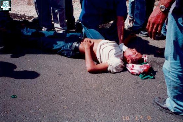 An Arab youth lies bloodied on the ground after being shot by Israeli Border Police. (photo courtesy of Adalah)