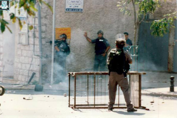 Israeli Border Police officers aim assault rifles toward Arab demonstrators in northern Israel during October 2000. (Courtesy of Adalah)